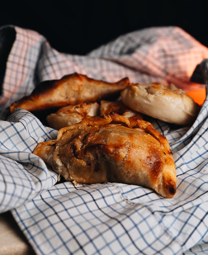 Warm Argentinian empanadas on a checkered cloth, capturing a rustic culinary scene.